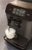A close-up shot of a Philips coffee machine frothing milk into a glass cup. Produktbild-Vorschau