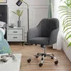 A gray velvet office chair is placed next to a nightstand in a bedroom setting. Produktbild-Vorschau