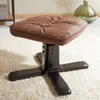 A brown leather-look ottoman with a black base sits on a fluffy white rug. Produktbild-Vorschau