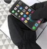 A person wearing black gloves is using a smartphone. Anteprima dell’immagine prodotto