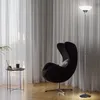 A modern living room scene with a black egg chair and a floor lamp. Produktbild-Vorschau