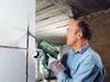 A man is using a Bosch drill to cut a groove in a wall. Produktbild-Vorschau