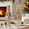 Two wooden nutcrackers are displayed on a wooden table dusted with artificial snow, with a fireplace and a Christmas tree in the background. Produktbild-Vorschau