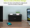 A black cable management box is shown on a wooden desk, with a phone charging and a laptop connected to it. A small potted plant sits on top of the box. Produktbild-Vorschau