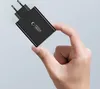 A hand holding a black power adapter. Produktbild-Vorschau