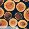 A close-up view of stacked wood logs with visible growth rings. Produktbild-Vorschau