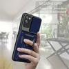 A hand is holding a blue phone case with a ring holder, with a blurred indoor background. Produktbild-Vorschau