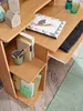 A close-up view of a wooden computer desk with a keyboard, books, and office supplies. Produktbild-Vorschau
