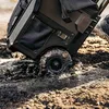 A black rolling tool case is stuck in mud, with one wheel submerged. Náhled obrázku produktu