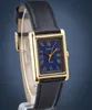 A close-up studio shot of a gold-toned rectangular Casio watch with a blue dial and a black leather strap. Produktbild-Vorschau