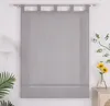A gray Roman blind is hanging on a white wall, with a lamp on the left and a vase with flowers on the right. Produktbild-Vorschau