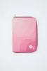 A pink zippered case with a wavy pattern and two circular logos on the bottom right corner, set against a white background. Produktbild-Vorschau