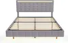 A grey upholstered bed frame with a tufted headboard and integrated LED lighting, shown from the front with the mattress support slats visible. Náhled obrázku produktu