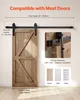A wooden barn door is shown installed on a black sliding track system against a light-colored wall. Podgląd zdjęcia produktu