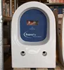A white toilet bowl is shown from the front, with a blue insert featuring the Villeroy & Boch logo and 'SupraFix' branding. The toilet is on a wooden pallet, with metal scaffolding to the left and cardboard packaging to the right. Anteprima dell’immagine prodotto