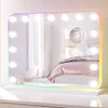 A vanity mirror with LED lights and RGB color options, placed on a white surface in a bedroom setting. Náhled obrázku produktu