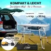 A camping table being advertised, shown with a car trunk and mountainous background. Produktbild-Vorschau