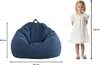 A child standing next to a beanbag chair, with dimensions indicated. Voir les images du produit