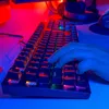 A hand is typing on a mechanical gaming keyboard with RGB lighting. Produktbild-Vorschau