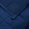 A close-up view of a quilted navy blue blanket. Produktbild-Vorschau