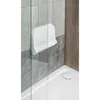 A white folding shower seat mounted on a tiled wall inside a shower stall. Anteprima dell’immagine prodotto