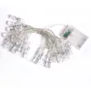 A string of LED lights with clear clips, attached to a battery pack. Produktbild-Vorschau