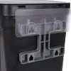 A close-up view of the back of a black trash can, showing a gray plastic mounting bracket with hooks attached to it, and a clear plastic flap above the bracket. Voir les images du produit
