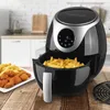 A black and silver GOURMETmaxx digital air fryer is shown on a wooden table, with a basket full of french fries and a plate of fried chicken and fries next to it. The background is a kitchen setting. Produktbild-Vorschau