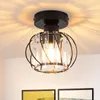 A black ceiling light with a crystal shade is mounted on a white ceiling, casting decorative shadows. Voir les images du produit