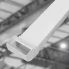 A close-up, angled view of a white plastic cable duct with a rectangular opening at the end. The background is blurred and shows the interior structure of a building, possibly a warehouse or industrial space. Anteprima dell’immagine prodotto