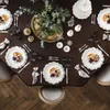 A beautifully set dining table with plates, cutlery, and a centerpiece. Voir les images du produit
