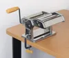 A pasta machine clamped to a wooden table. Náhled obrázku produktu