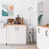 A kitchen scene with a high chair folded and standing next to cabinets. The high chair has an illustration indicating it can be folded. Produktbild-Vorschau