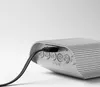 A close-up shot of a silver digital alarm clock with a USB cable plugged into it. Podgląd zdjęcia produktu