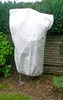 A white plant protection bag is covering a plant in a garden setting. Produktbild-Vorschau