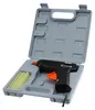 A black and orange hot glue gun with yellow glue sticks, displayed inside its gray plastic case. Produktbild-Vorschau