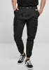 A person wearing black cargo pants and black sneakers. Anteprima dell’immagine prodotto