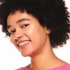 A close-up portrait of a young woman smiling. Voir les images du produit