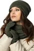 A woman wearing a green beanie, scarf, and gloves, with a beige jacket. Produktbild-Vorschau