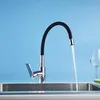 A modern kitchen faucet with a flexible black hose is shown in a stainless steel sink, with water running. Náhľad obrázku produktu