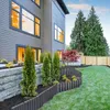 A backyard scene with a modern house, landscaping, and a wooden fence. Náhľad obrázku produktu