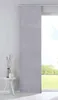 A grey panel curtain hangs in front of a window with a view of a garden. Produktbild-Vorschau