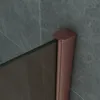 A close-up view of a shower door's corner, showing the bronze glass and copper profile against a tiled wall. Produktbild-Vorschau
