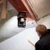 A person is inspecting a ceiling beam with a light source illuminating the area. Produktbild-Vorschau