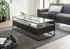 A modern living room scene featuring a glass-top coffee table with storage, a sofa, and a rug. Produktbild-Vorschau
