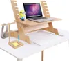 A wooden laptop stand is set up on a white desk, complete with a laptop, keyboard, mouse, headphones, and a small Minion figurine. Produktbild-Vorschau
