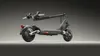A studio shot of a dark gray electric scooter against a gradient gray background. Produktbild-Vorschau