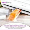 A vacuum sealer machine is shown sealing a piece of salmon in a plastic bag, with rolls of vacuum seal bags in the foreground. Anteprima dell’immagine prodotto