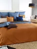 A neatly made bed with multiple pillows and a duvet. Produktbild-Vorschau