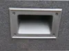 A close-up view of a recessed handle on a textured surface. Produktbild-Vorschau